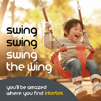 An infant smiling while riding a playground swing